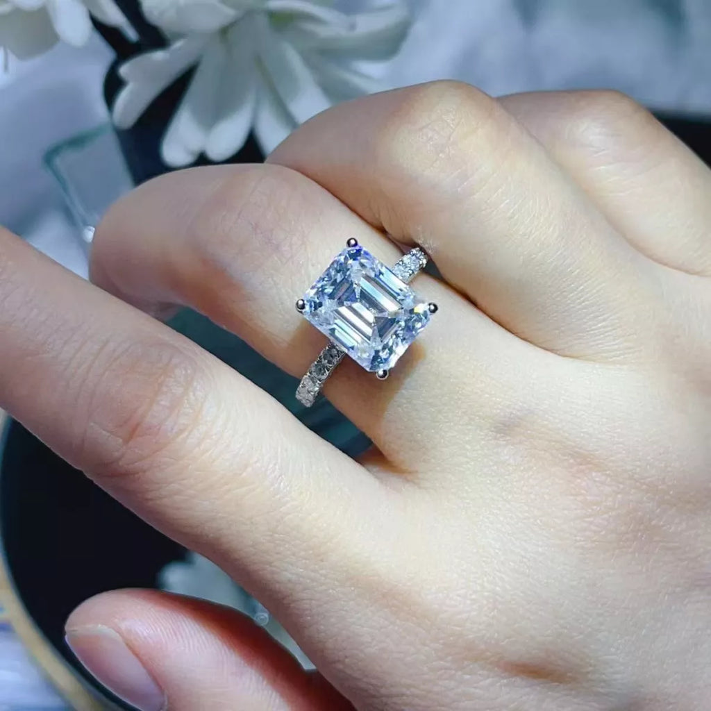 Diamond ring on a finger with a blurred floral background