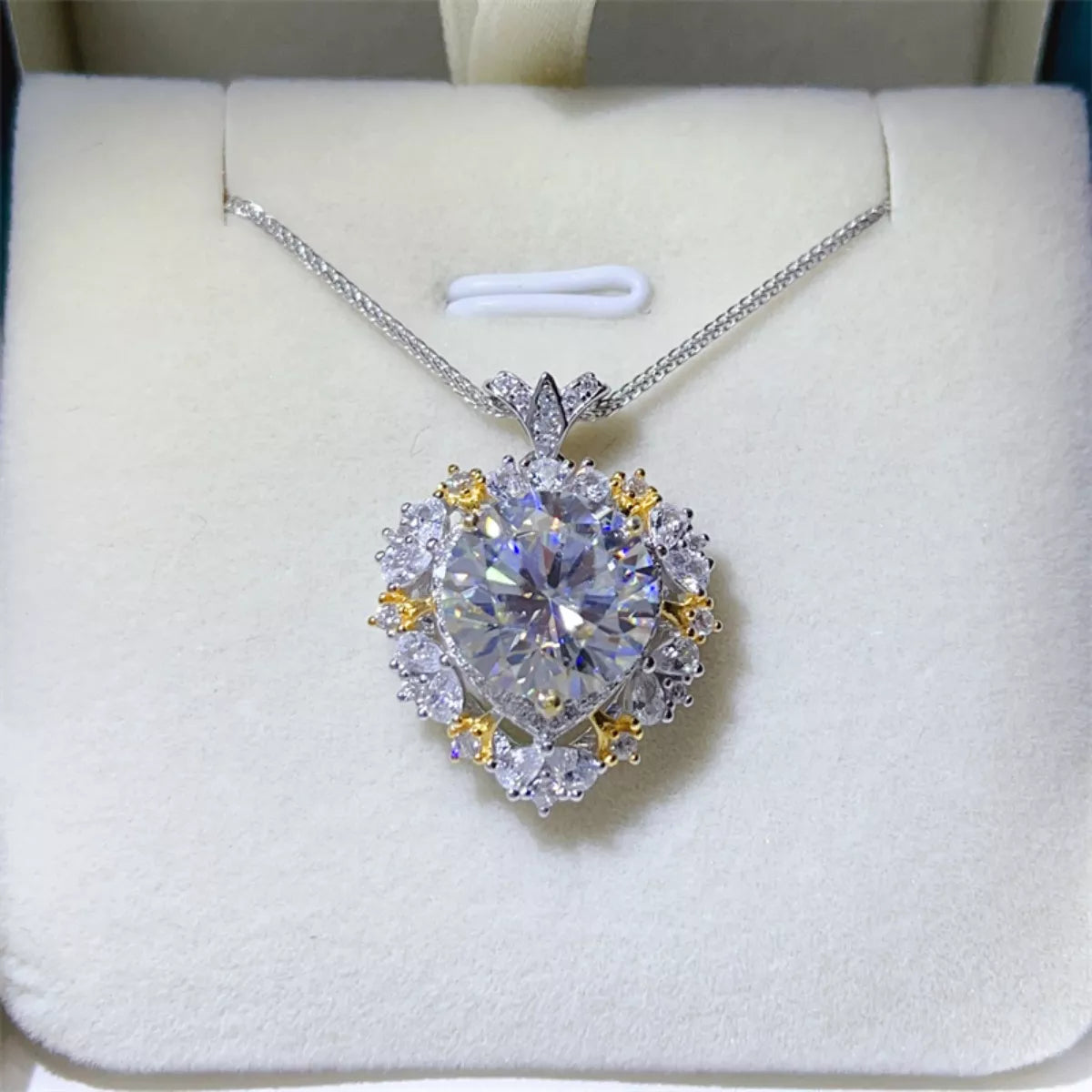 Diamond necklace with a heart-shaped pendant on a white cushion