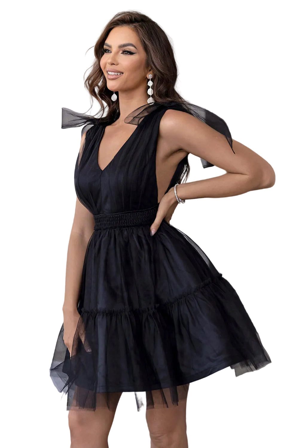 Woman wearing a black dress with sheer panels in an indoor setting