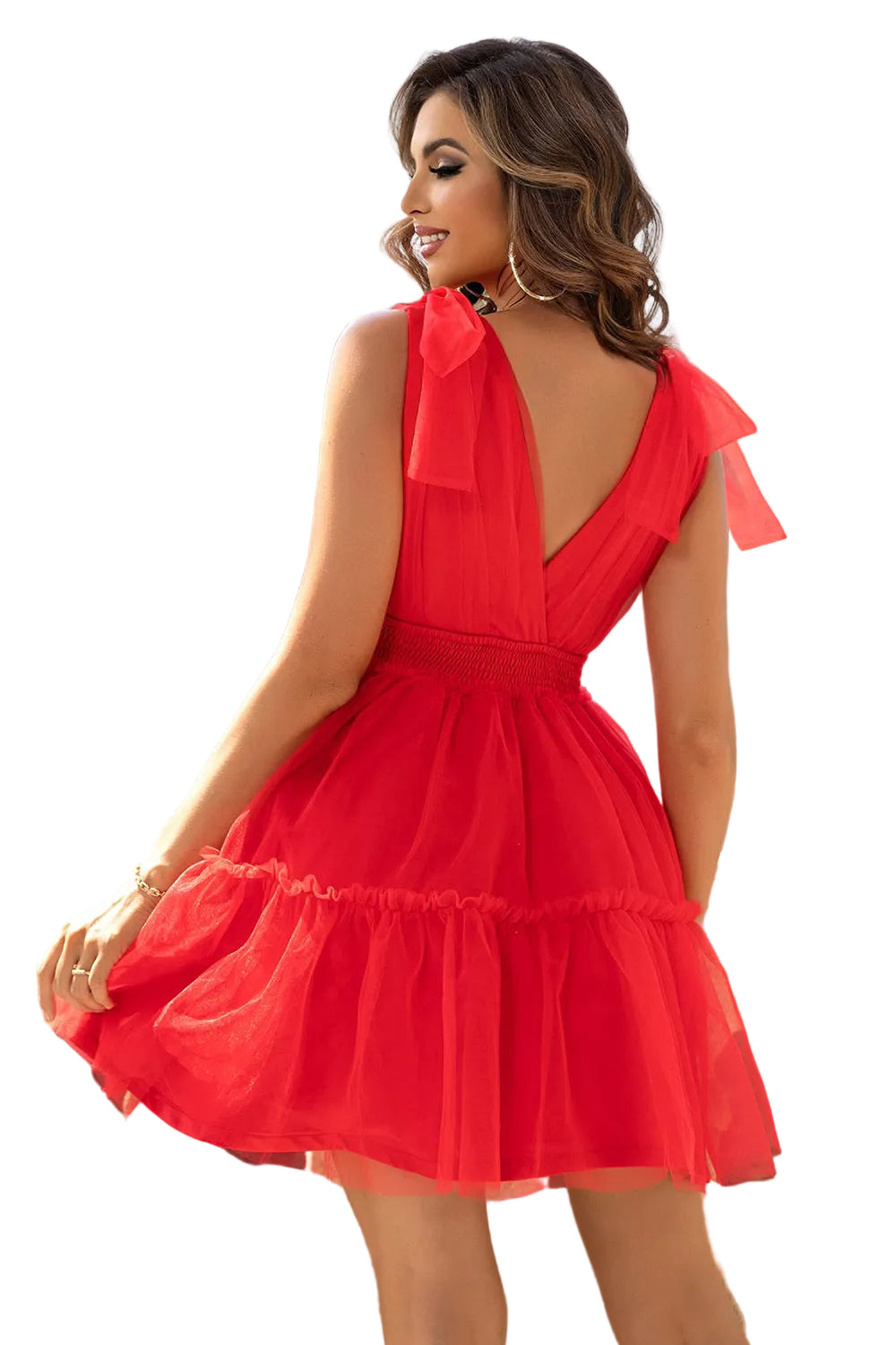 Woman wearing a red dress with a bow detail in an outdoor setting