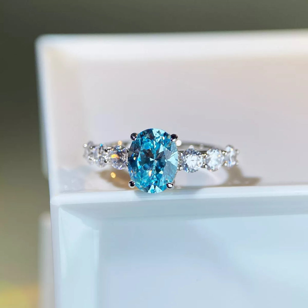 Ring with a blue gemstone and diamond accents on a white surface