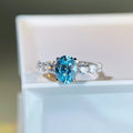 Ring with a blue gemstone and diamond accents on a white surface
