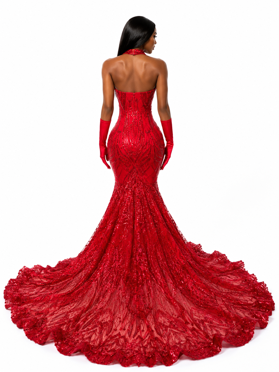 A model shown from the back wearing a strapless red mermaid gown with a long train, matching red gloves, and a red halter-style neckpiece against a plain white background.