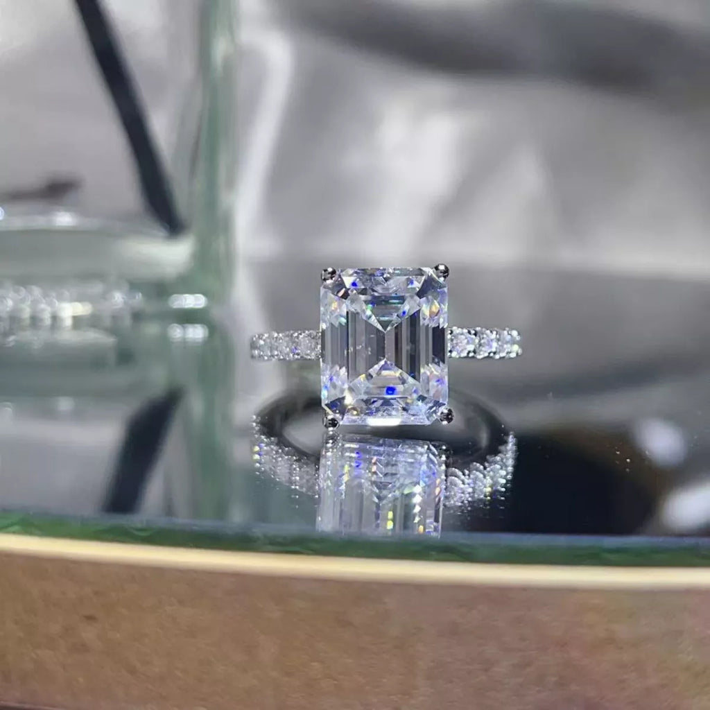 Moissanite Diamond ring on a reflective surface with a blurred background | Konfidential Kouture 